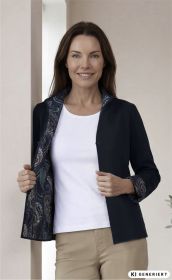 Frau trägt dunkelblaue Baumwoll-Mix-Strickjacke mit gemustertem Innenfutter, weiße Bluse und beigefarbene Hose, steht vor hellem Hintergrund, hält Jackenseiten geöffnet und lächelt freundlich