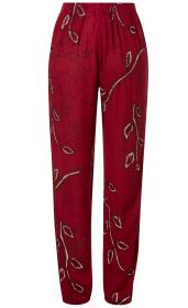 Rote Viskose-Hose mit elastischem Bund, lockerer Passform und dezentem floralen Muster in Beige und Dunkelrot, die sich entlang der Beine verteilt