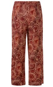 rote Viskose-Hose mit weitem Bein, bedruckt mit beigen, konzentrischen Kreis-Mustern, elastischer Bund ohne sichtbare Taschen, gerade geschnitten, leichte und fließende Stoffqualität