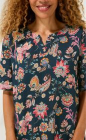Baumwoll-Kleid mit dunklem Grund und buntem floralen Muster, V-Ausschnitt mit kleinem Schlitz, lockere kurze Ärmel, Nahaufnahme Oberkörper einer Frau mit lockigen Haaren und leichtem Lächeln.