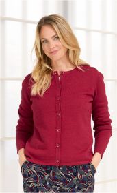 Frau trägt rote Leinen-Mix-Strickjacke mit Knöpfen, langärmlig, kombiniert mit gemusterten Hosen, Hände in den Taschen, vor hellem Hintergrund, mittellange blonde Haare, lächelnder Gesichtsausdruck
