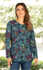 Frau trägt bunt gemustertes Baumwoll-Shirt mit langem Arm und V-Ausschnitt, Muster in Blau-, Grün-, Rot- und Gelbtönen, dazu blaue Jeans, unscharfer grüner Hintergrund