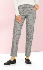 Baumwoll-Mix Hose Damen, hellgrau mit floralem Muster in dunklen und rosa Tönen, gerade geschnitten, mit Hosentaschen, kombiniert mit weißem Oberteil und schwarzen Slippern, vor rosa Hintergrund