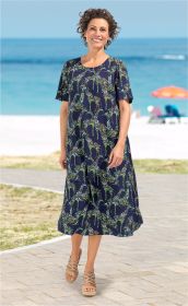 Frau trägt blaues Viskose-Kleid mit buntem Giraffen-Muster, kurze Ärmel, knöchellang, Sandalen, steht am Strandweg mit Meeresblick und buntem Sonnenschirm im Hintergrund, lächelt, kurze lockige Haare
