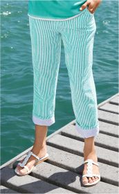 Frau trägt mintgrün-weiß gestreifte Baumwoll-Hose mit hochgekrempelten Beinen und weißen Sandalen, steht auf Steg am Wasser