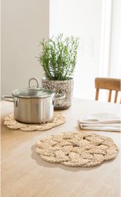 Zwei runde Jute-Untersetzer auf einem Holztisch, einer mit einem Edelstahltopf mit Glasdeckel darauf, im Hintergrund ein grauer Blumentopf mit grünem Kraut, daneben ein gefaltetes weißes Geschirrtuch, heller Raum mit Holztisch und Stuhl