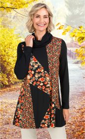 Frau mit kurz blondem Haar trägt schwarzes Viskose-Mix-Shirt mit langem Arm und buntem Blumenmuster, steht lächelnd auf herbstlichem Waldweg mit gelben Blättern im Hintergrund