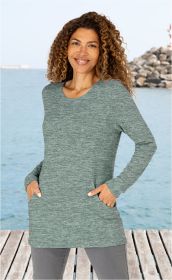 Frau mit lockigem Haar trägt langärmeliges graugrünes Viskose-Mix-Shirt mit Rundhalsausschnitt und Eingrifftaschen, steht auf Holzsteg vor Wasser und Felsen, lächelt freundlich