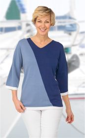 Frau trägt zweifarbigen Viskose-Pullover in Blau- und Hellblau-Tönen mit V-Ausschnitt, 3/4-Ärmeln und weißen Abschlüssen, kombiniert mit weißer Hose, Hintergrund unscharf, hell, maritimer Stil