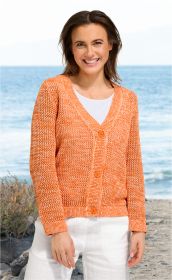 Lächende Frau trägt orange-weiß melierte Baumwoll-Strickjacke mit V-Ausschnitt und Knopfleiste, weiße Hose, Sommer-Setting am Meer im Hintergrund, natürlicher Look