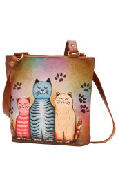 Leder-Handtasche mit farbiger Front, darauf drei gemalte Katzen in Rosa, Blau und Orange, umgeben von Pfotenabdrücken, mit verstellbarem Schulterriemen und goldfarbenen Metallringen.