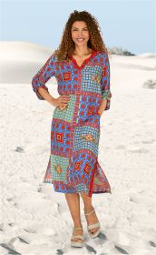 Frau mit lockigem Haar trägt buntes Viskose-Kleid mit blau-rotem Patchworkmuster, 3/4-Ärmeln und Knopfleiste, beige Sandalen, steht im Sand unter klarem Himmel, lächelnd, rechte Hand in Hüfte gestützt, linke Hand in Tasche