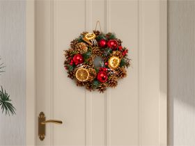 Deko-Kranz aus Zapfen, getrockneten Orangenscheiben, Zimtstangen, roten Weihnachtskugeln und grünen Tannenzweigen an beige lackierter Tür mit goldenem Türgriff hängend