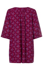 Rückenansicht einer violett-rot gemusterten Viskose-Tunika mit halblangen Ärmeln und leichtem Faltenwurf am Rücken.