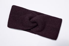 dunkelviolettes, gestricktes Baumwoll-Mix-Stirnband mit gedrehtem Knoten-Motiv, liegend auf weißem Hintergrund