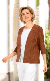 Frau trägt braune strukturierte Baumwoll-Jacke mit dreiviertel Ärmeln, darunter weißes Oberteil und weiße Hose mit Kordelzug, stehende Pose, heller Hintergrund mit Säulen und grünen Pflanzen