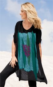 Frau im schwarzen Viskose-Kaftan mit abstraktem Muster in Blau, Grün und Magenta, stehend vor hellem Sand und blauem Himmel, seitlich wehend blonde Haare, schwarze Hose, lächelnd, Hand auf Oberschenkel stützend