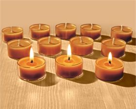 Zwölf Bienenwachsteelichter in transparenter Halterung auf hellem Holztisch, drei vorne brennend mit sichtbarer Flamme, neun hinten unbrennend, warme gelb-braune Farbtöne, weich beleuchtet, Produkt Bienenwachsteelicht 12/S.