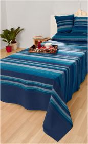 Baumwoll-Überwurf 250x240 cm mit blauen und grauen Streifen auf einem Bett, dazu passende Kissen, Holztablett mit Teller und Flasche, heller Holzfußboden, kleiner Beistelltisch mit Buch, zwei Pflanzen im Topf, weiße Wand im Hintergrund.