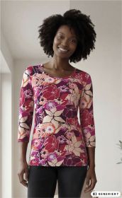 Frau trägt eng anliegendes Viskose-Shirt mit buntem floralen Muster in Rot-, Pink- und Beigetönen, Rundhalsausschnitt und dreiviertellangen Ärmeln, dazu schwarze Hose, stehender Innenraum mit hellem Hintergrund