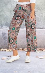 Beinansicht einer Viskose-Hose mit weitem Bein und buntem Mandala-Muster in Türkis, Orange und Beige, kombiniert mit weißen Sneakern, vor grauer Wand und Boden mit kleinen Blättern.