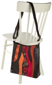 Leder-Tasche mit verstellbarem Schulterriemen, dekorativen orange, roten und schwarzen Mustern, hängend an der Rückenlehne eines weißen Holzstuhls