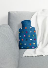 blaue Filz-Wärmflaschenhülle mit bunten Punkten liegend auf grauem Sofa neben weißer Decke