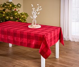 Rote Tischdecke mit kariertem Muster auf weißem Tisch, dekoriert mit rundem Holztablett, Glasvase mit weißen Zweigen und Weihnachtsdeko, grüner beleuchteter Weihnachtsbaum und Fenster mit weißem Vorhang im Hintergrund