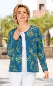 Frau trägt blaue Baumwoll-Strickjacke mit grünem Blumenmuster, Knopfleiste, darunter weißes Shirt und weiße Hose, steht draußen bei Sonnenschein mit verschwommenen Palmen im Hintergrund