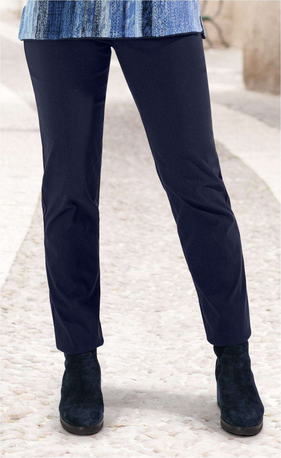 Dunkelblaue Viskose-Mix-Hose in geradem Schnitt, getragen mit schwarzen Stiefeletten auf gepflastertem Weg, unter blau gestreiftem Oberteil sichtbar