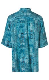 Rückansicht einer kurzärmligen Viskose-Bluse in blau mit gemustertem Design aus floralen und geometrischen Formen in Schwarz und Weiß