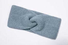 Hellblaues, gestricktes Baumwoll-Mix-Stirnband mit gedrehtem Knoten-Detail, flach liegend auf weißem Hintergrund, weiche und warme Struktur, für kühlen Wettergebrauch geeignet