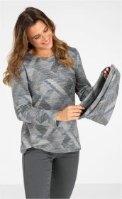 Frau trägt graues Viskose-Mix Shirt mit geometrischem Muster in Blau- und Grautönen, langärmlig, locker sitzend, zeigt Ärmel mit ausgestelltem Ende, kombiniert mit dunkler Hose, lächelt und schaut auf den Ärmel