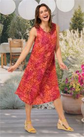 Frau im bunten, ärmellosen Viskose-Kleid mit rot-gelbem Muster, lachend und tanzend, helle Wedges, sommerlicher Garten mit Terrasse, Tischen, Pflanzen und Papierlaternen im Hintergrund.