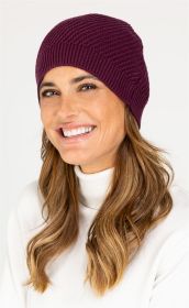 Frau mit langen braunen Haaren trägt eine dunkelviolette Baumwoll-Mix-Mütze und einen weißen Rollkragenpullover, lächelt leicht vor hellem Hintergrund.
