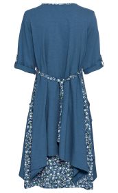 Blaues Baumwoll-Kleid mit kurzärmeligem Oberteil, floral gemustertem Unterrock, tailliertem Bindegürtel und seitlichen Taschen, Rückansicht, fließender Schnitt, Kragen mit floralem Muster, lockere, bequeme Passform.